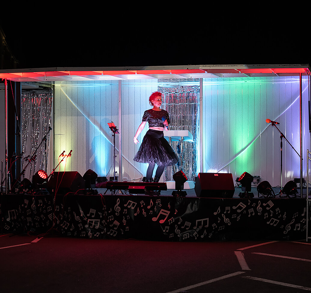 A view of one performer on stage lit up at night